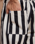 Close up of Anthony's hand in the back pocket of Black Stripe Work Pants in White