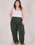 Ashley is 5'7" and wearing 1XL Heritage Trousers in Swamp Green and Cropped Tank Top in vintage tee off-white