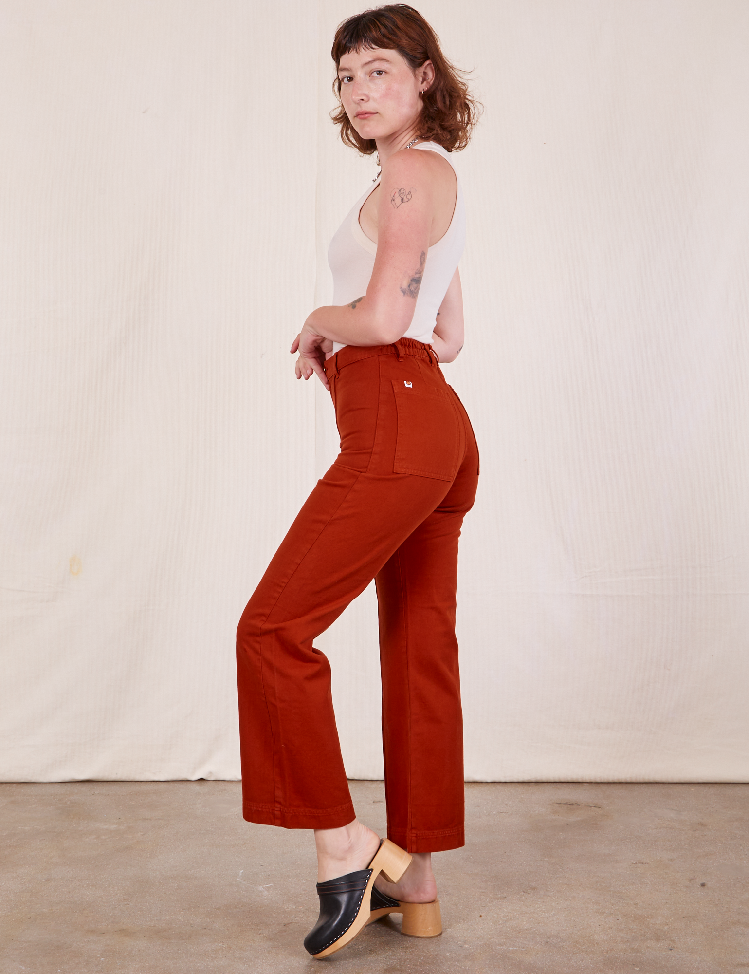 Side view of Western Pants in Paprika and Tank Top in vintage tee off-white worn by Alex