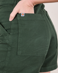 Close up of Alex's hand in the back pocket of Classic Work Shorts in Swamp Green