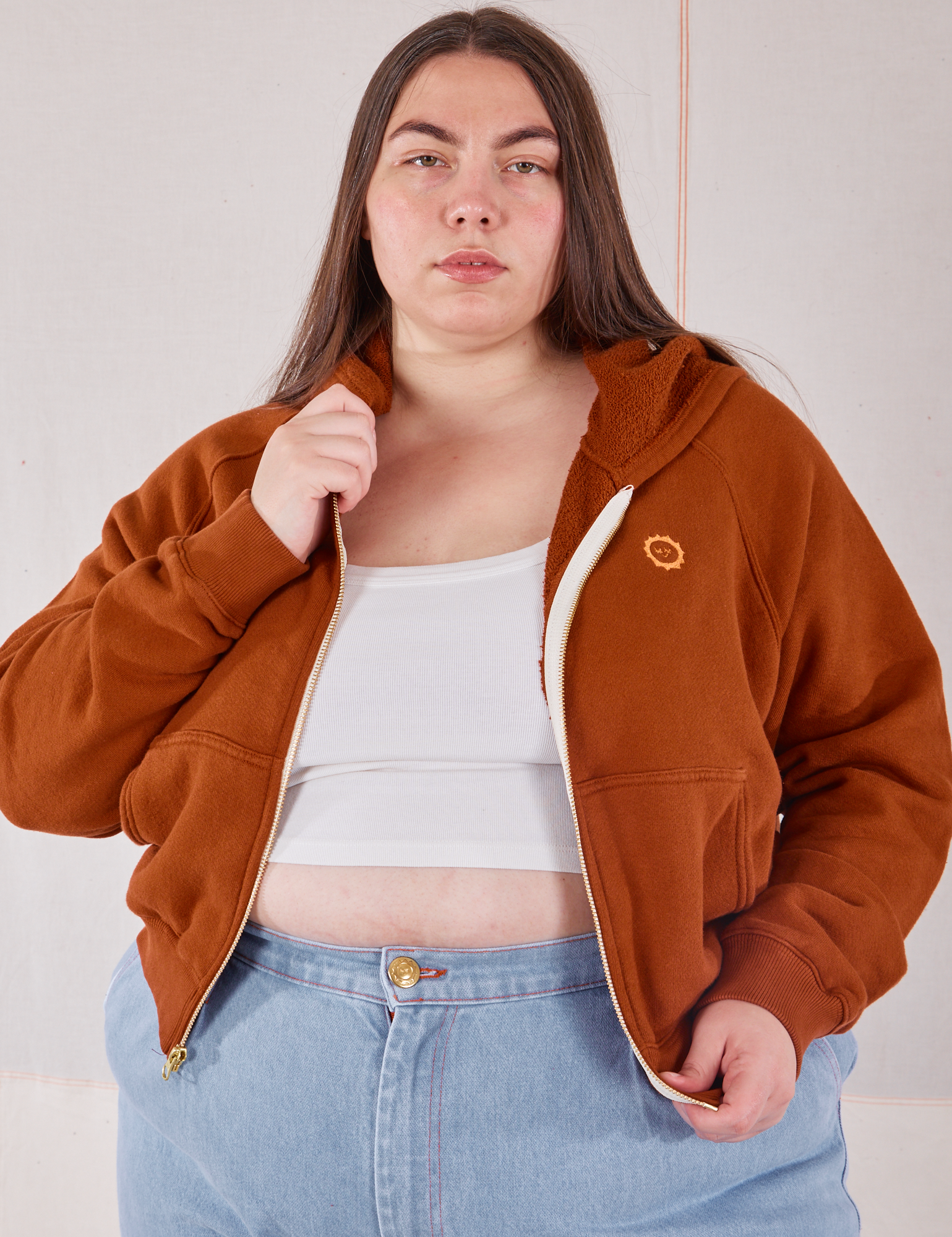 Marielena is wearing Cropped Zip Hoodie in Burnt Terracotta and a vintage off-white Cropped Tank underneath