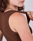 Close up of Alex tugging on the strap of the Cropped Tank Top in Fudgesicle Brown