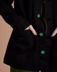 Close up of Alex's hand in the front pocket of Ripstop Field Coat in Basic Black