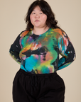 Ashley is 5’7” and wearing L Long Sleeve Baby Tee in Rainbow Magic Waters