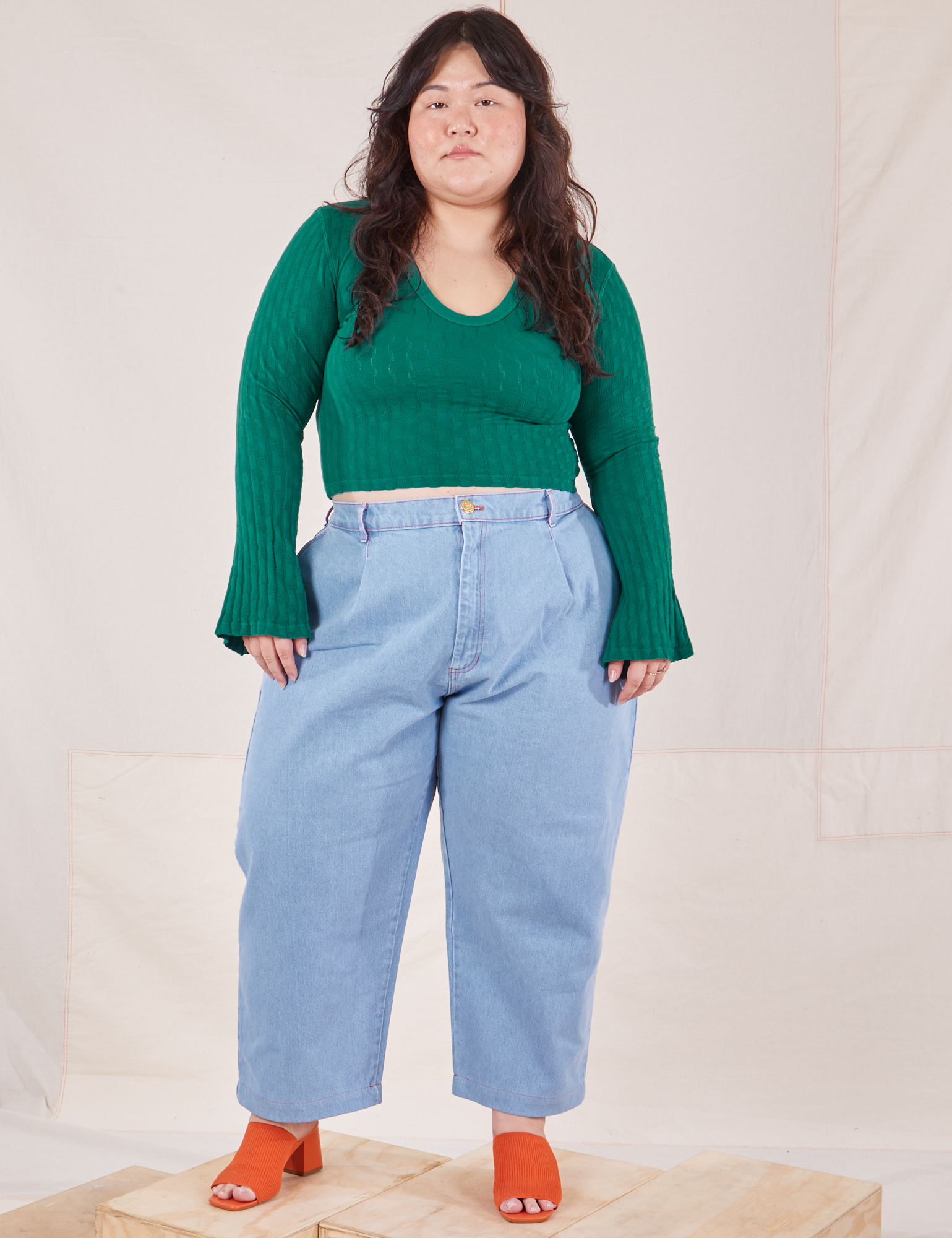 Ashley is wearing Bell Sleeve Top in Hunter Green and light wash Trouser Jeans