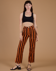 Alex is 5’8” and wearing XXS Black Stripe Work Pants in Construction Orange paired with black mini crop tank