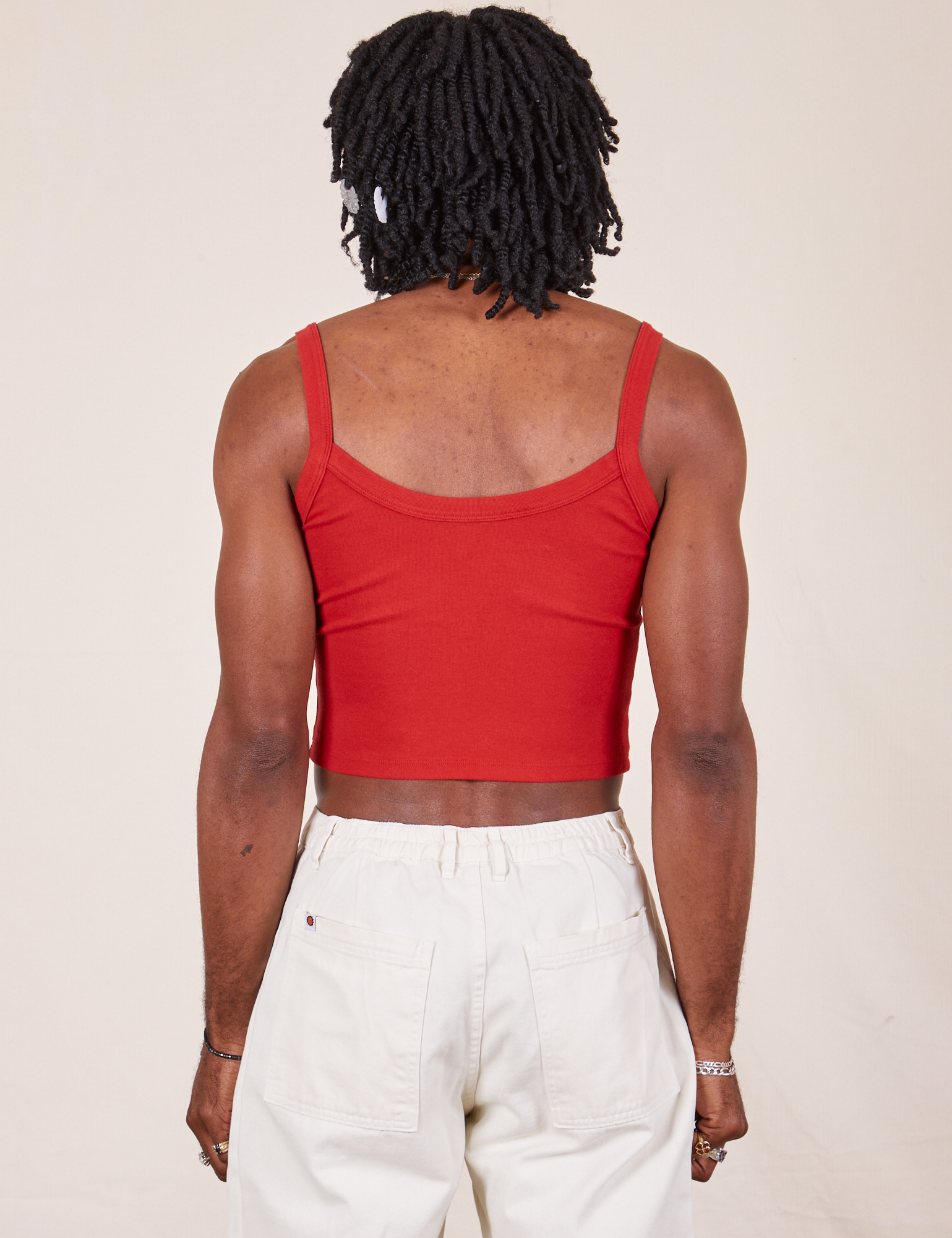 Back view of Cropped Cami in Mustang Red and vintage tee off-white Western Pants worn by Jerrod