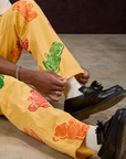 Close up of Gummy Bear Paintstamped Work Pants in Butter Yellow pant legs on Isaac