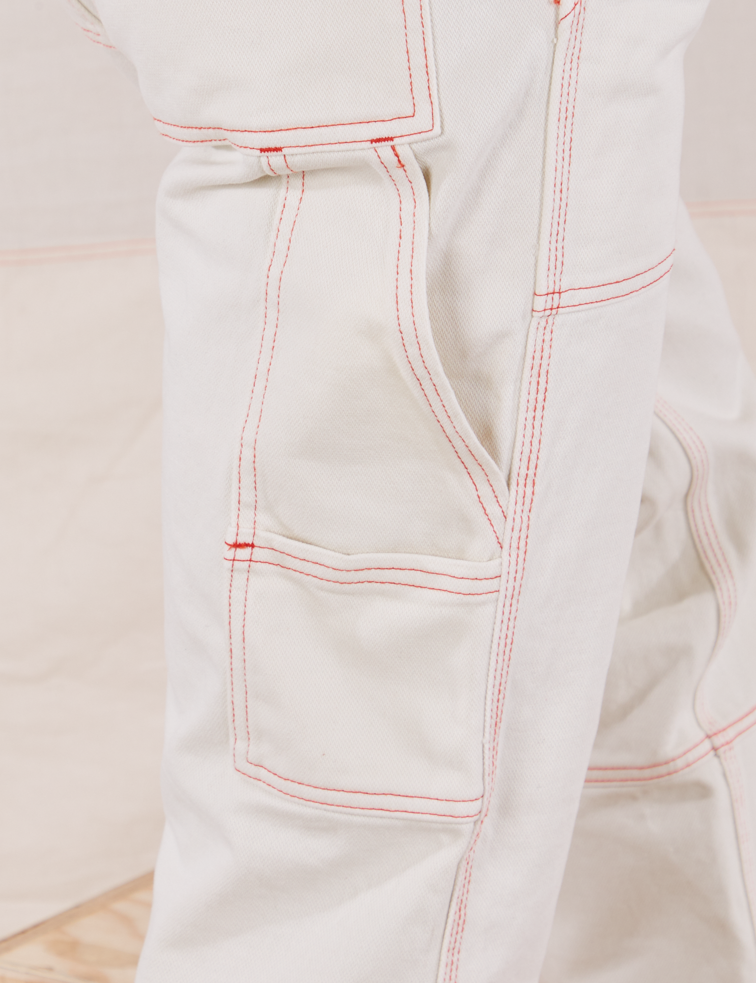 Carpenter Jeans in Vintage Off-White pant leg close up of contrast orange topstitching. 