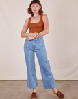 Alex is 5'8" and wearing P Cropped Tank Top in Burnt Terracotta paired with light wash Sailor Jeans
