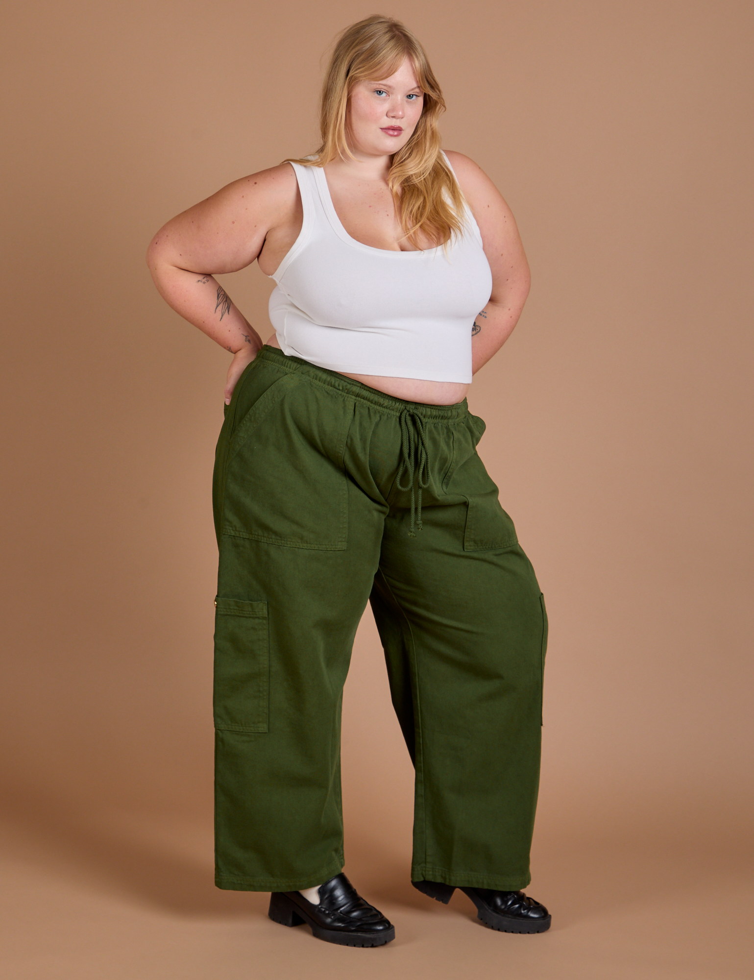 Angled view of Drop Pocket Cargo Pants in Evergreen and Cropped Tank in vintage tee white