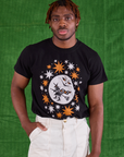 Issac is wearing Halloween Organic Tee in Moon tucked into vintage tee off-white Work Pants