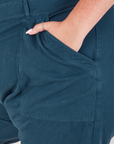 Heritage Short Sleeve Jumpsuit in Lagoon front pocket close up. Katie has her hand in the pocket.