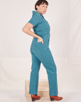 Heritage Short Sleeve Jumpsuit in Marine Blue side view on Tiara with hands in both back pockets