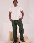 Issac 5’10” is and wearing M Heritage Trousers in Swamp Green paired with Organic Vintage Tee in vintage tee off-white