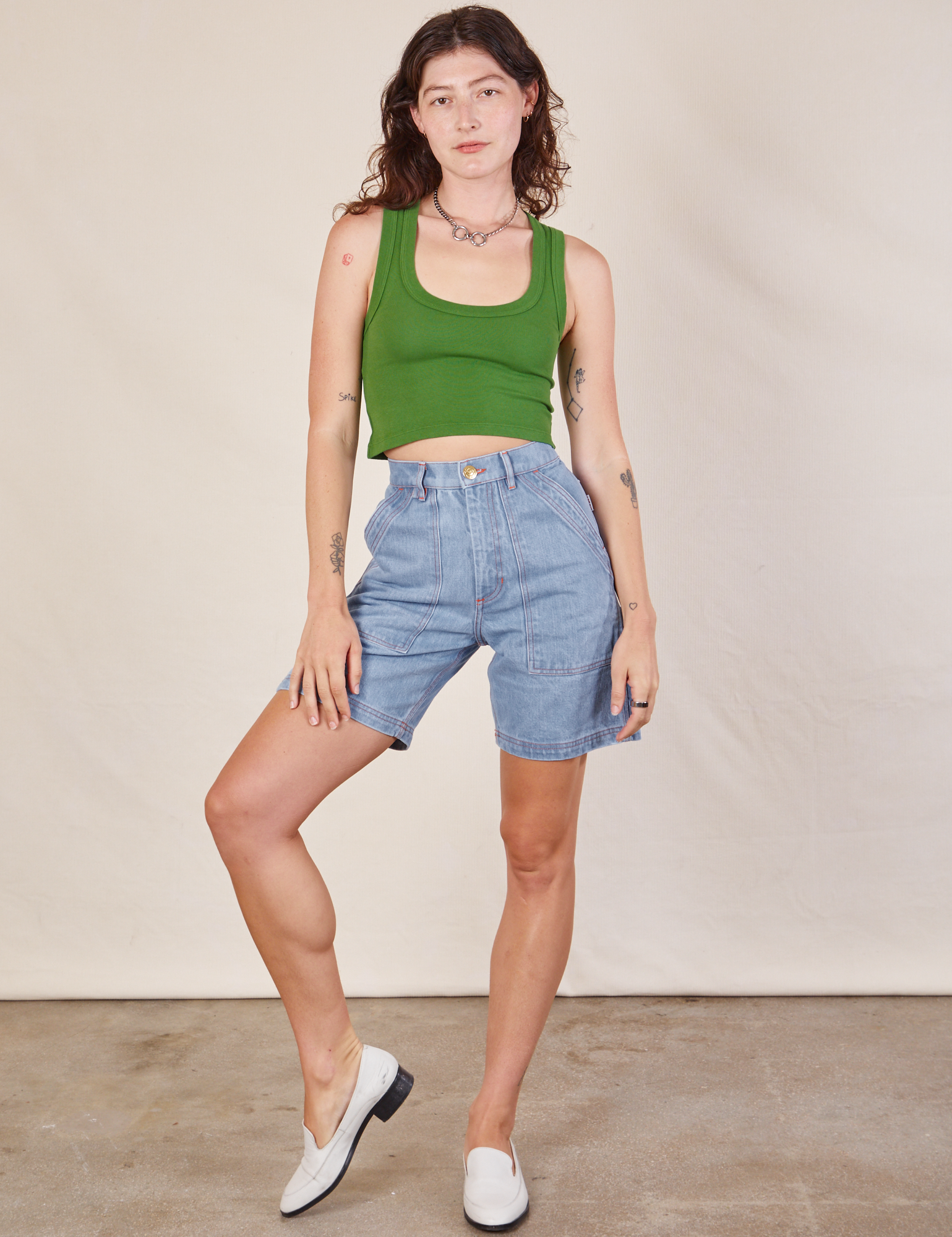 Alex is 5'8" and wearing XXS Carpenter Shorts in Light Wash paired with lawn green Cropped Tank