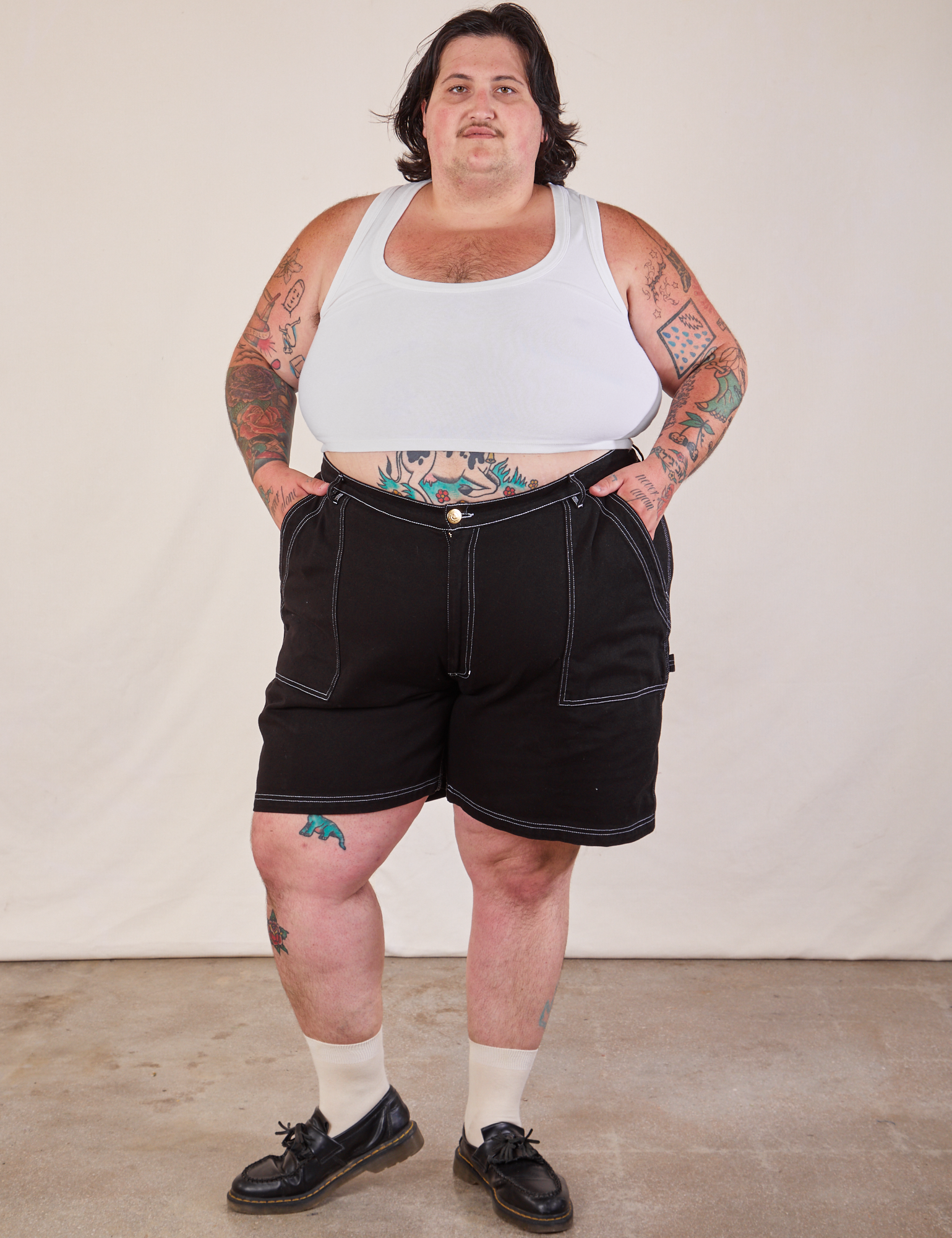 Sam is 5'10" and wearing 3XL Carpenter Shorts in Basic Black paired with a Cropped Tank in vintage tee off-white.