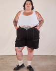 Sam is 5'10" and wearing 3XL Carpenter Shorts in Basic Black paired with a Cropped Tank in vintage tee off-white.