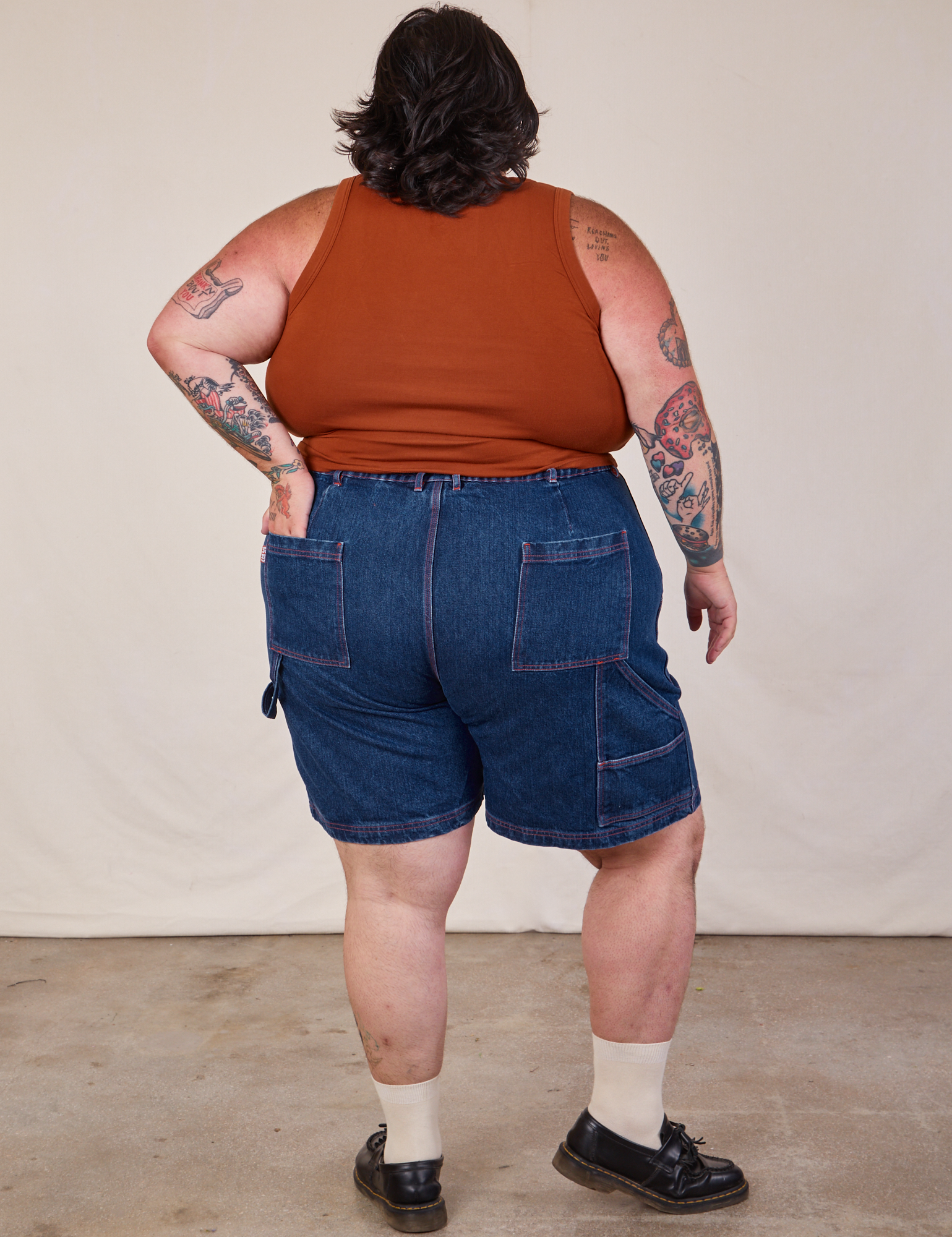 Back view of Carpenter Shorts in Dark Wash and burnt terracotta Cropped Tank on Sam