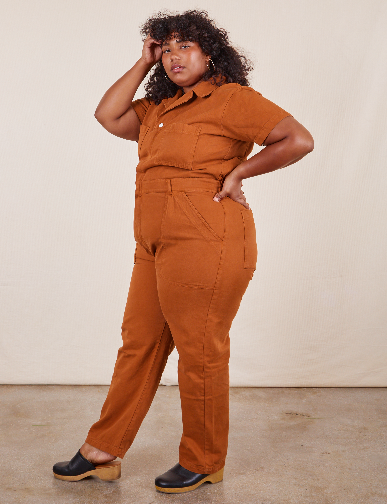 Side view of Short Sleeve Jumpsuit in Burnt Terracotta worn by Morgan