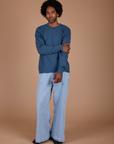Jerrod is wearing Long Sleeve Burly Tee in French Blue and light wash Indigo Wide Leg Trousers