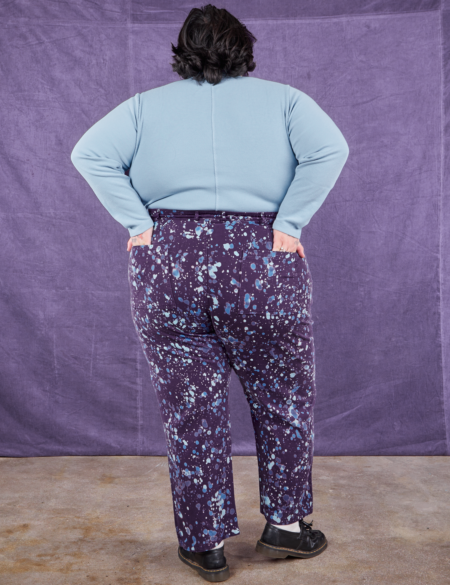 Back view of Marble Splatter Work Pants in Nebula Purple and baby blue Long Sleeve Fisherman Polo on Sam