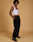 Side view of Baggy Mid-Rise Trousers in Basic Black and vintage tee white Cropped Tank on Jerrod