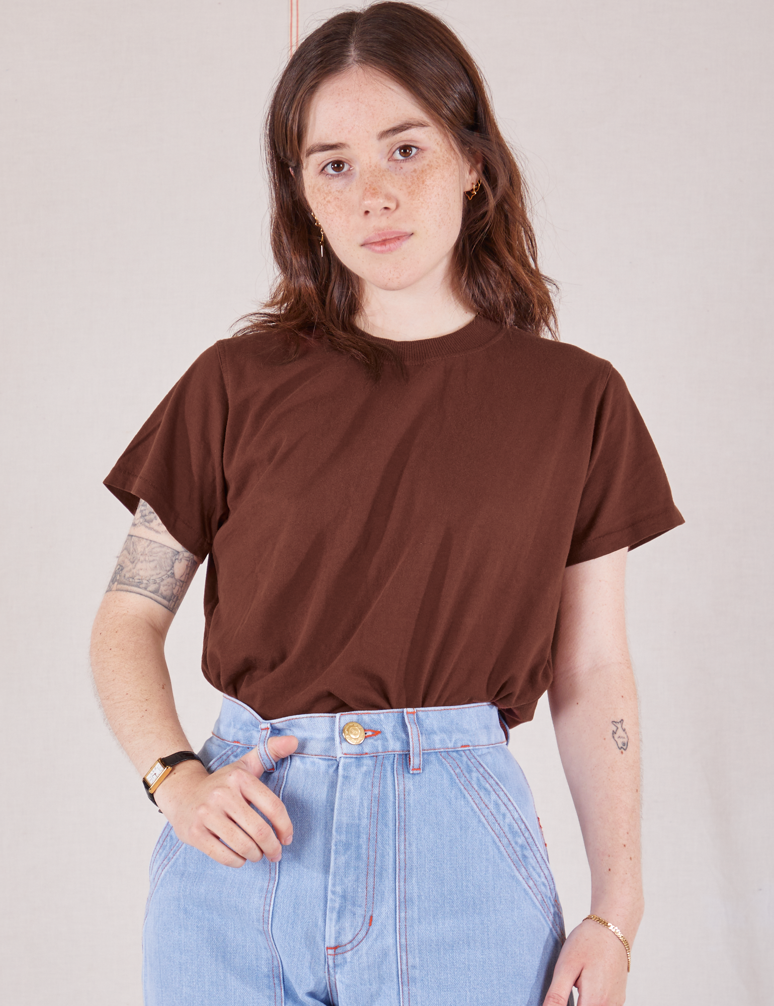 Hana is wearing Organic Vintage Tee in Fudgesicle Brown tucked into light wash Carpenter Jeans