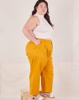 Side view of Organic Trousers in Mustard Yellow and Sleeveless Turtleneck in vintage tee off-white worn by Ashley