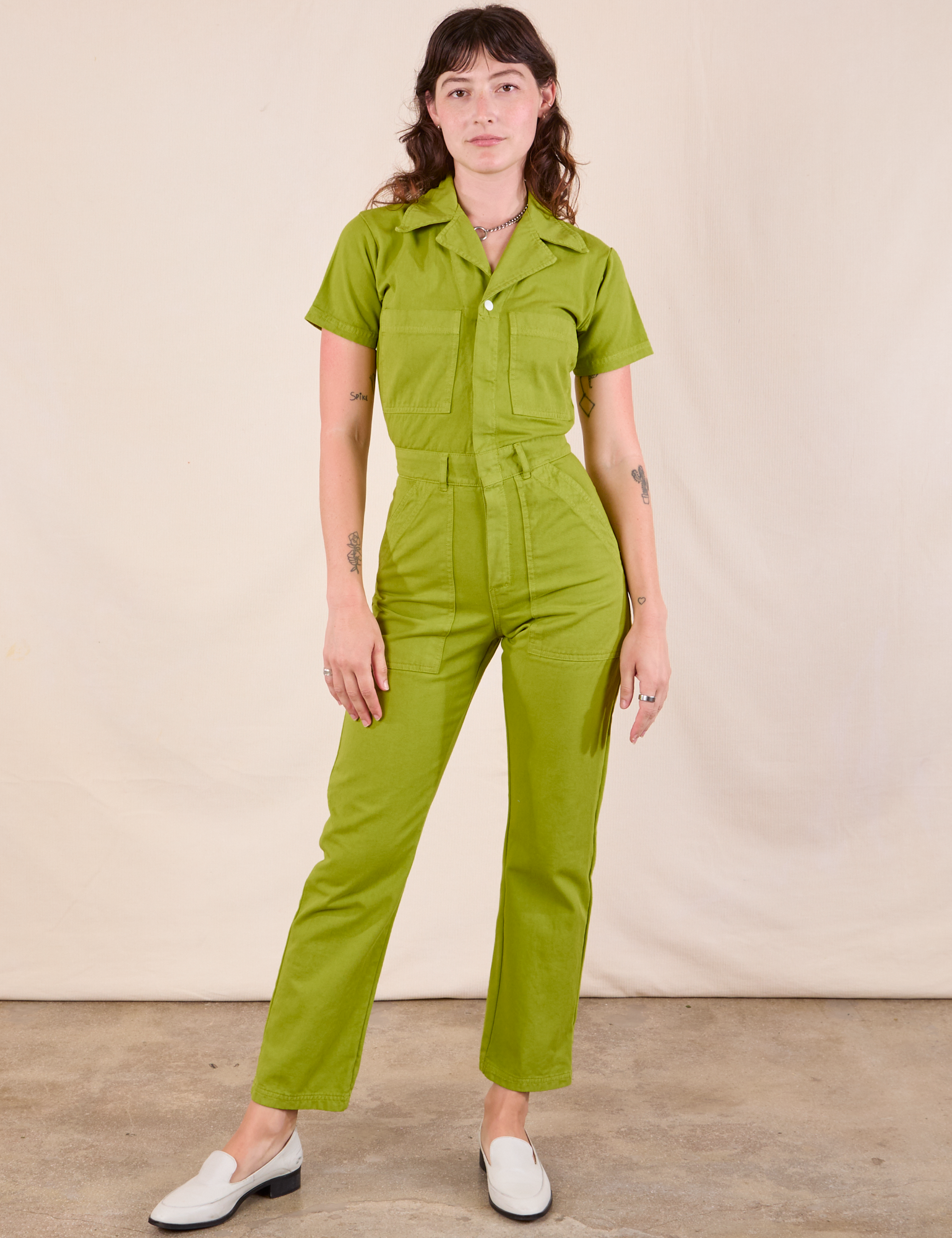 Alex is 5'8" and wearing XXS Short Sleeve Jumpsuit in Gross Green