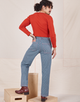 Back view of Railroad Stripe Denim Work Pants and paprika Long Sleeve V-Neck Tee worn by Jesse