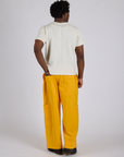 Back view of Drop Pocket Cargo Pants in Sunshine Yellow and Organic Vintage Tee in Vintage Tee White on Isaac