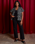 Kandia is wearing Spider Webs Pantry Button-Up with a black Cropped Tank underneath and black Work Pants