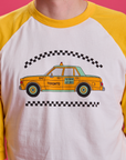 Taxi Raglan Tee in Toronto on Quinn. Yellow taxi graphic on the shirt.