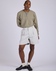 Jerrod is 6’3” and wearing M Pleated Trouser Shorts in Dishwater White paired with khaki grey Long Sleeve Burly Tee