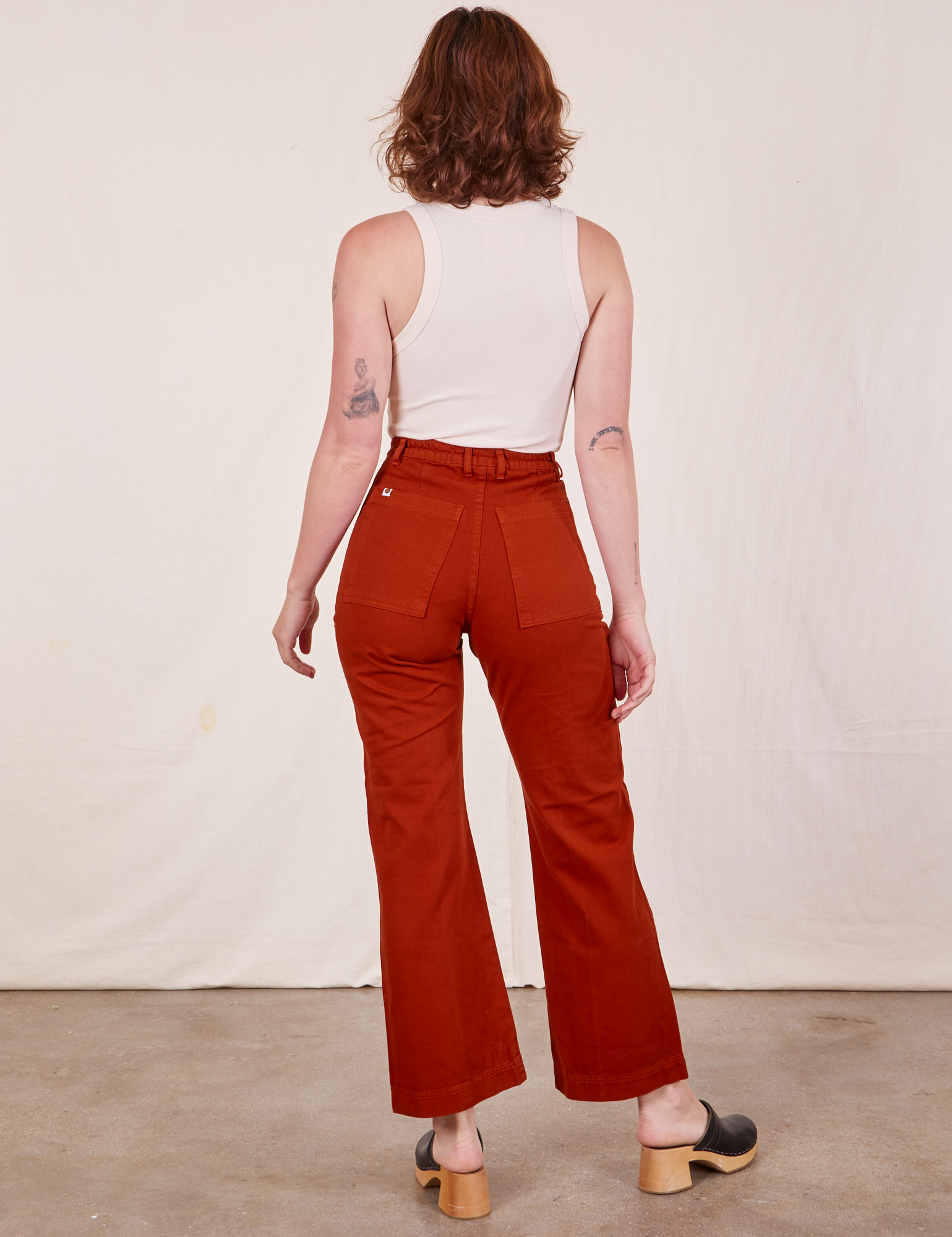 Back view of Western Pants in Paprika and Tank Top in vintage tee off-white worn by Alex