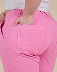 Close up of Ashley's hand in the back pocket of Work Pants in Bubblegum Pink