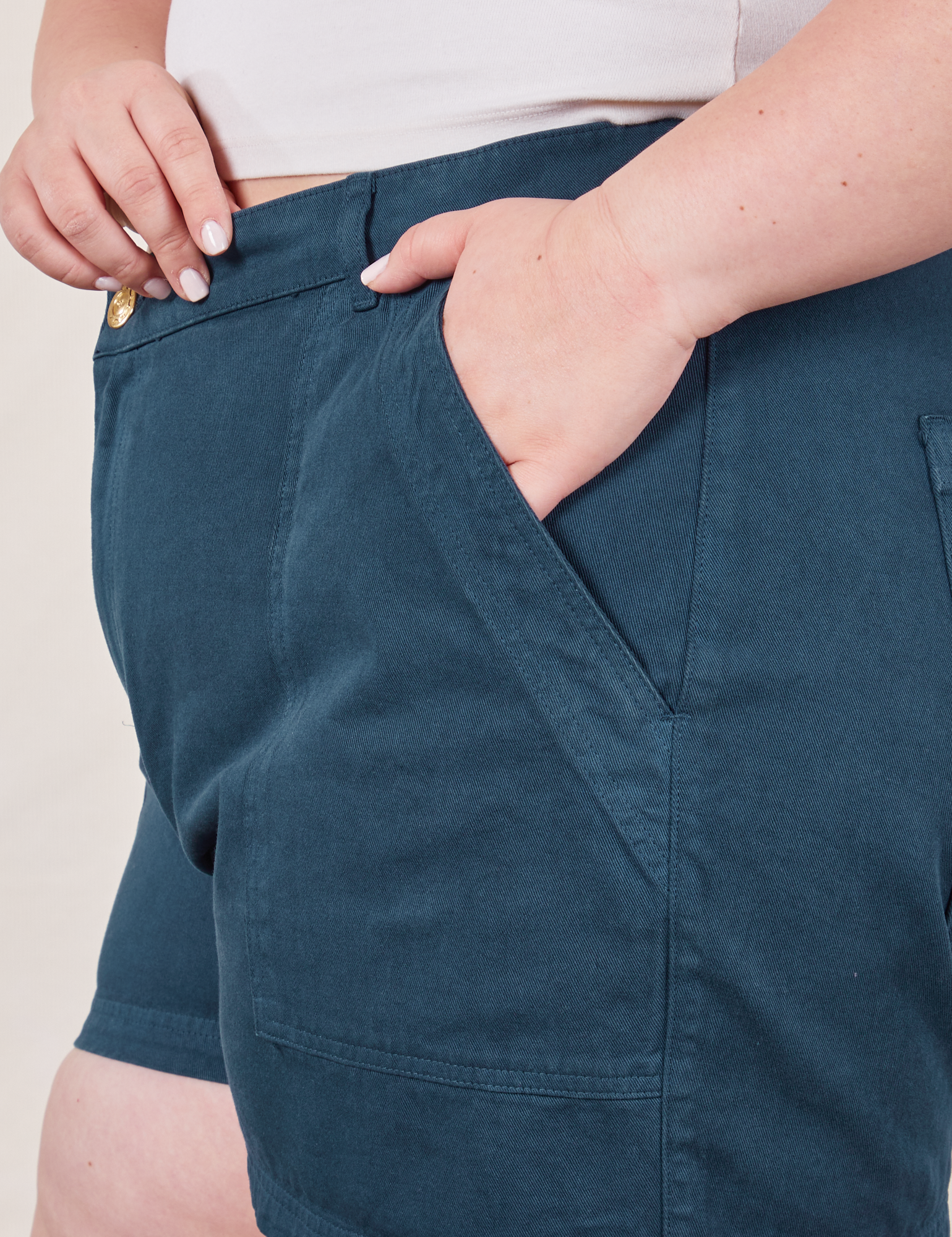 Classic Work Shorts in Lagoon front pocket close up. Ashley has her hand in the pocket.