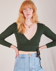 Margaret is 5’11” and wearing size 2 Wrap Top in Swamp Green