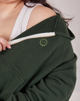 Cropped Zip Hoodie in Swamp Green close up of tonal embroidered sun baby logo