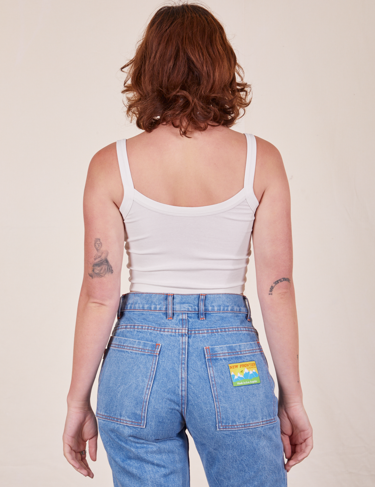 Back view of Cropped Cami in Vintage Tee Off-White and light wash Frontier Jeans worn by Alex