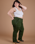 Side view of Carpenter Jeans in Evergreen and vintage tee white Cropped Tank on Ashley
