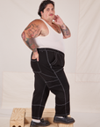Side view of Carpenter Jeans in Black and Tank Top in vintage tee off-white on Sam