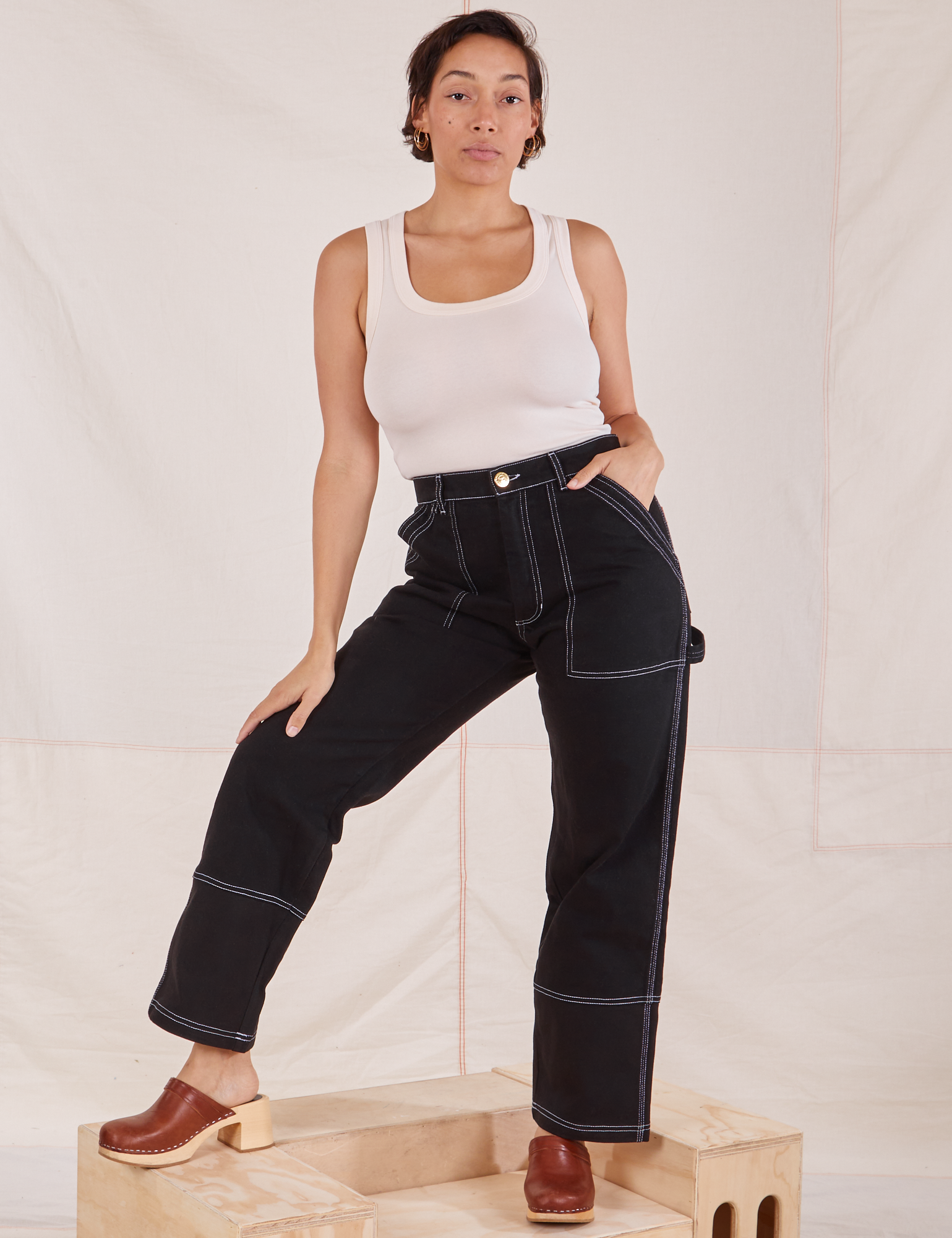 Tiara is 5&#39;4&quot; and wearing S Carpenter Jeans in Black paired with Tank Top in vintage tee off-white