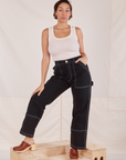 Tiara is 5'4" and wearing S Carpenter Jeans in Black paired with Tank Top in vintage tee off-white