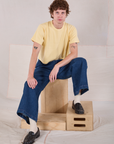 Quinn is wearing Cropped Burly Tee in Butter Yellow and wide leg trousers in dark wash