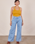 Tiara is wearing Halter Top in Mustard Yellow and light wash Sailor Jeans
