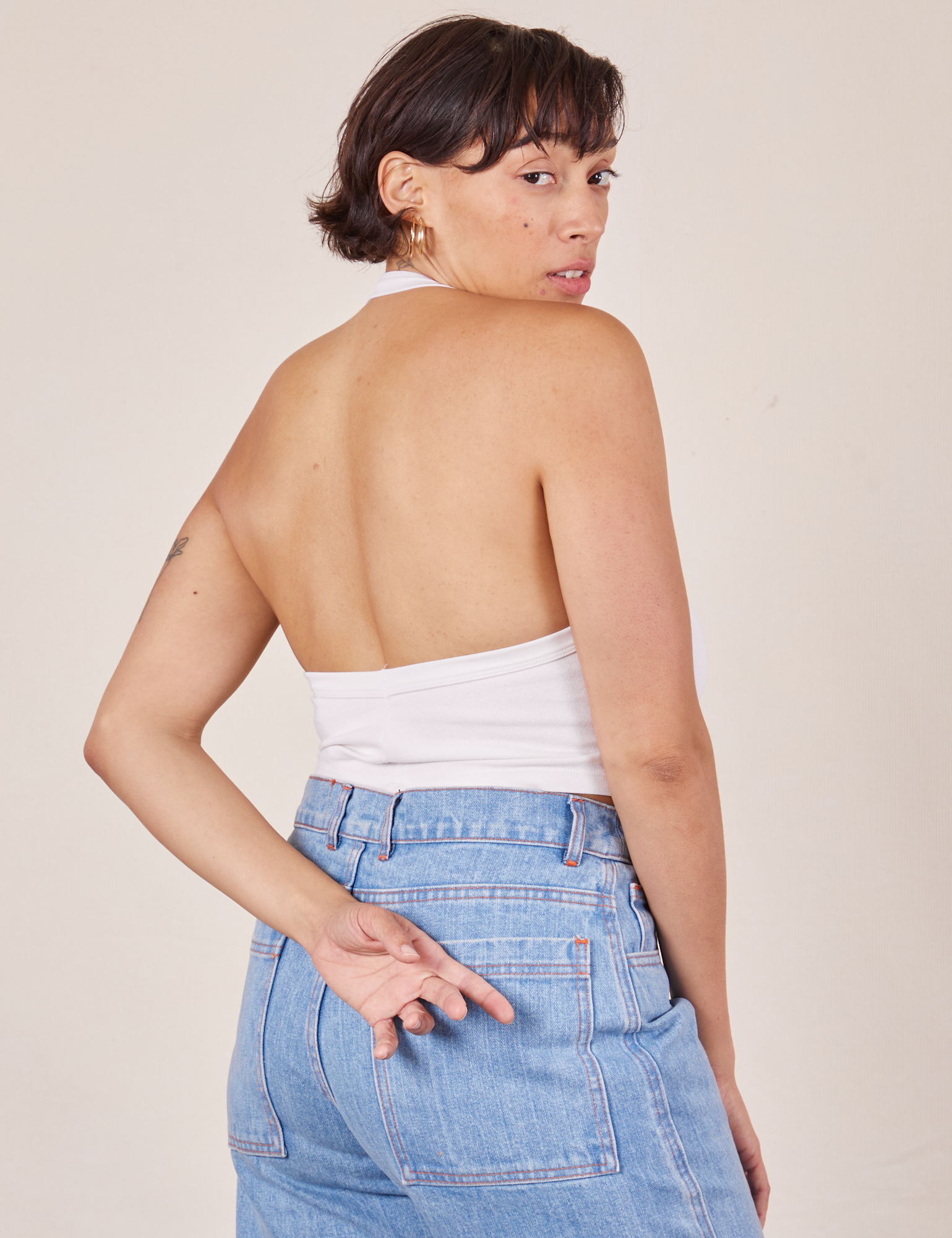 Back view of Halter Top in Vintage Tee Off-White and light wash Sailor Jeans worn by Tiara