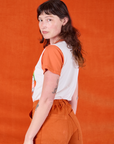 Angled back view of Anniversary Tee in Orange Blossom worn by Alex