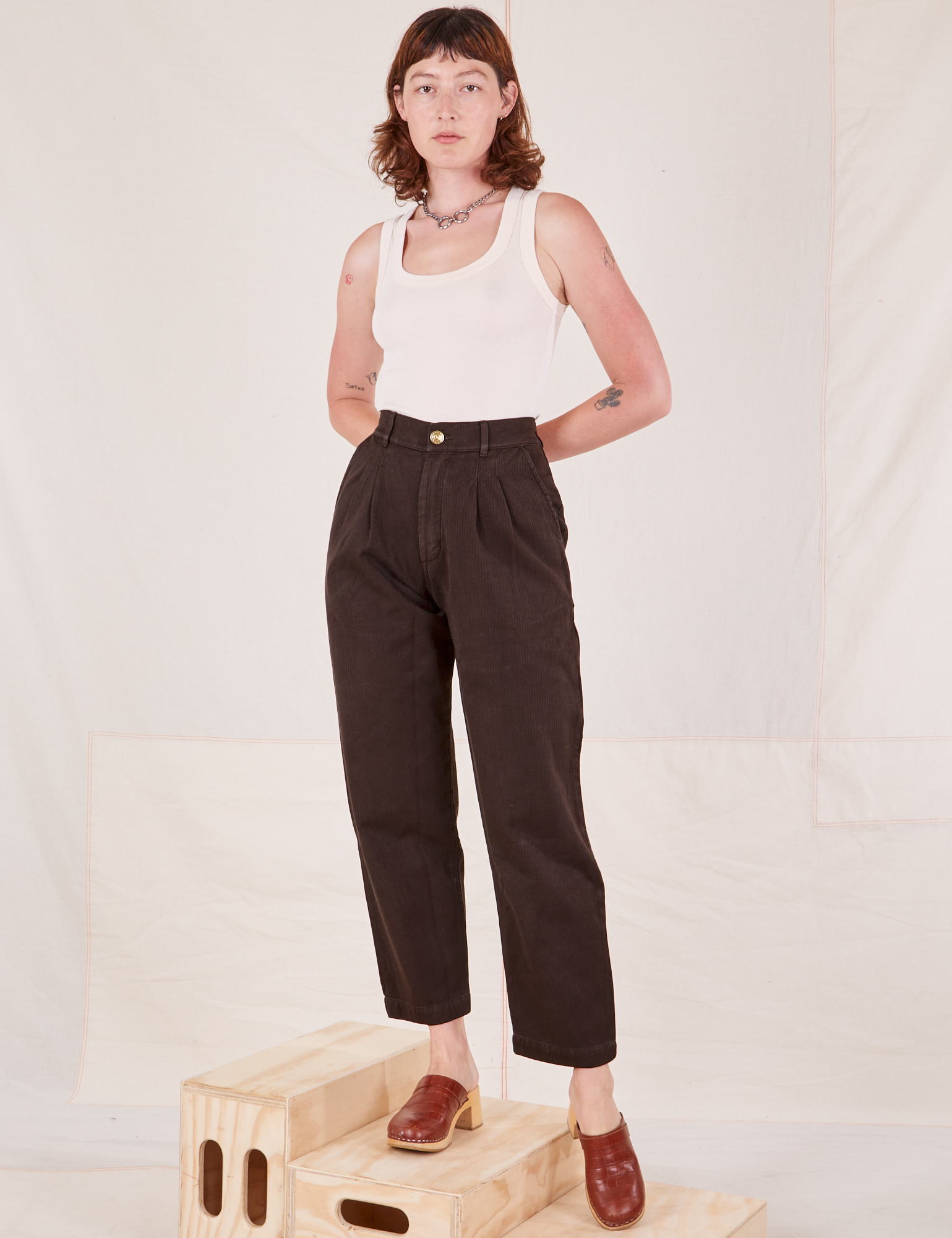 Alex is 5&#39;8&quot; and wearing XXS Heritage Trousers in Espresso Brown paired with vintage off-white Tank Top